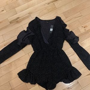 Long sleeve navy polkadot jumpsuit with cut out shoulders and frills